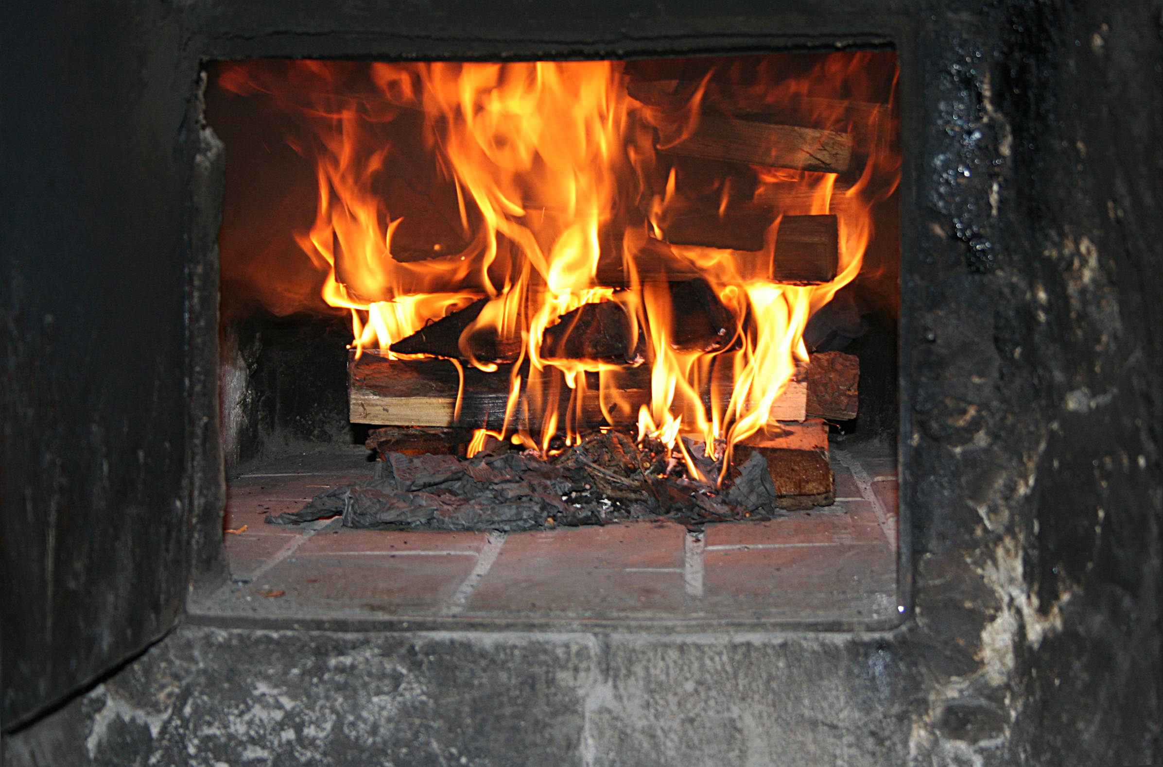 <p>Ein Holzbackofen wird angeheizt. Anschließend wird die Glut entfernt, der Ofen mit einem feuchten Stoffbündel ausgewischt und die Brote eingeschossen. Foto: <a href="http://www.tirolereigenbroetler.at/">Mag. Karl Eller</a></p>