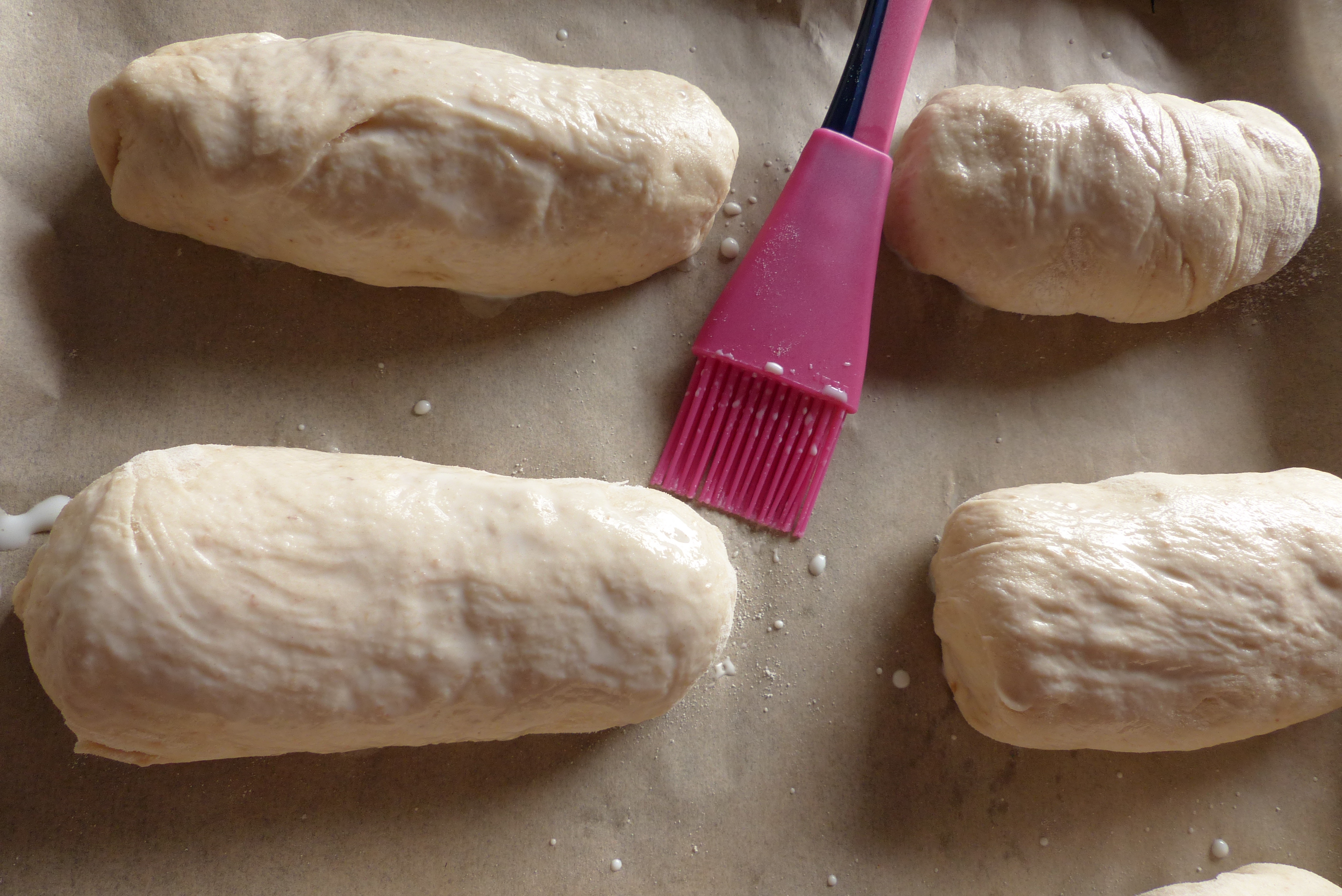 <p>Die Teiglinge vor dem Backen mit lauwarmer Milch bestreichen.</p>