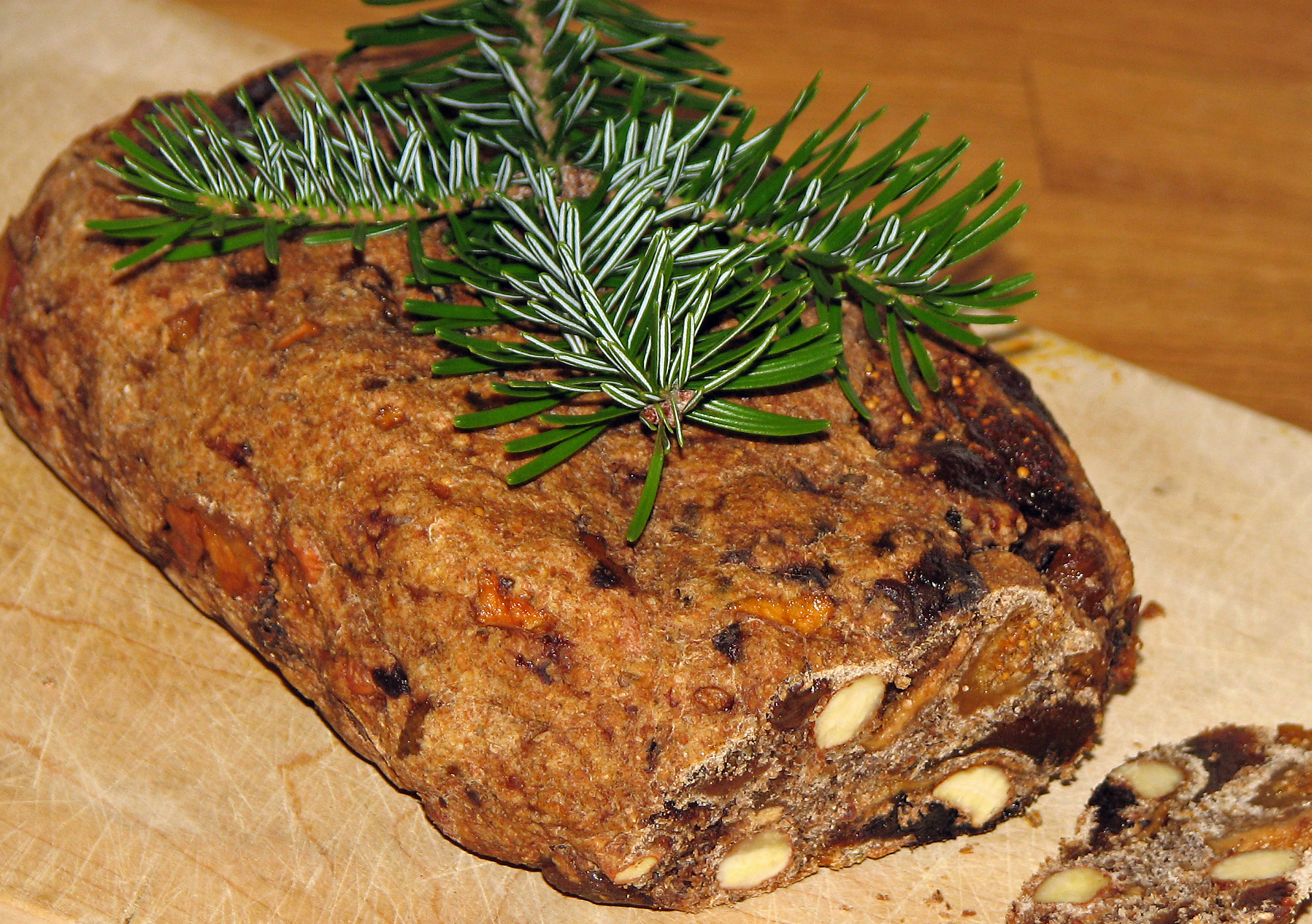 <p>Pinzgauer Kletzenbrot, angeschnitten auf dem Ahornschneidbrett der Osterthor-Mariedl. - Wer wird wohl das <a href="https://www.wildfind.com/artikel/zeltenanschneiden-und-neujahranschiessen">Scherzerl haben dürfen?</a></p>