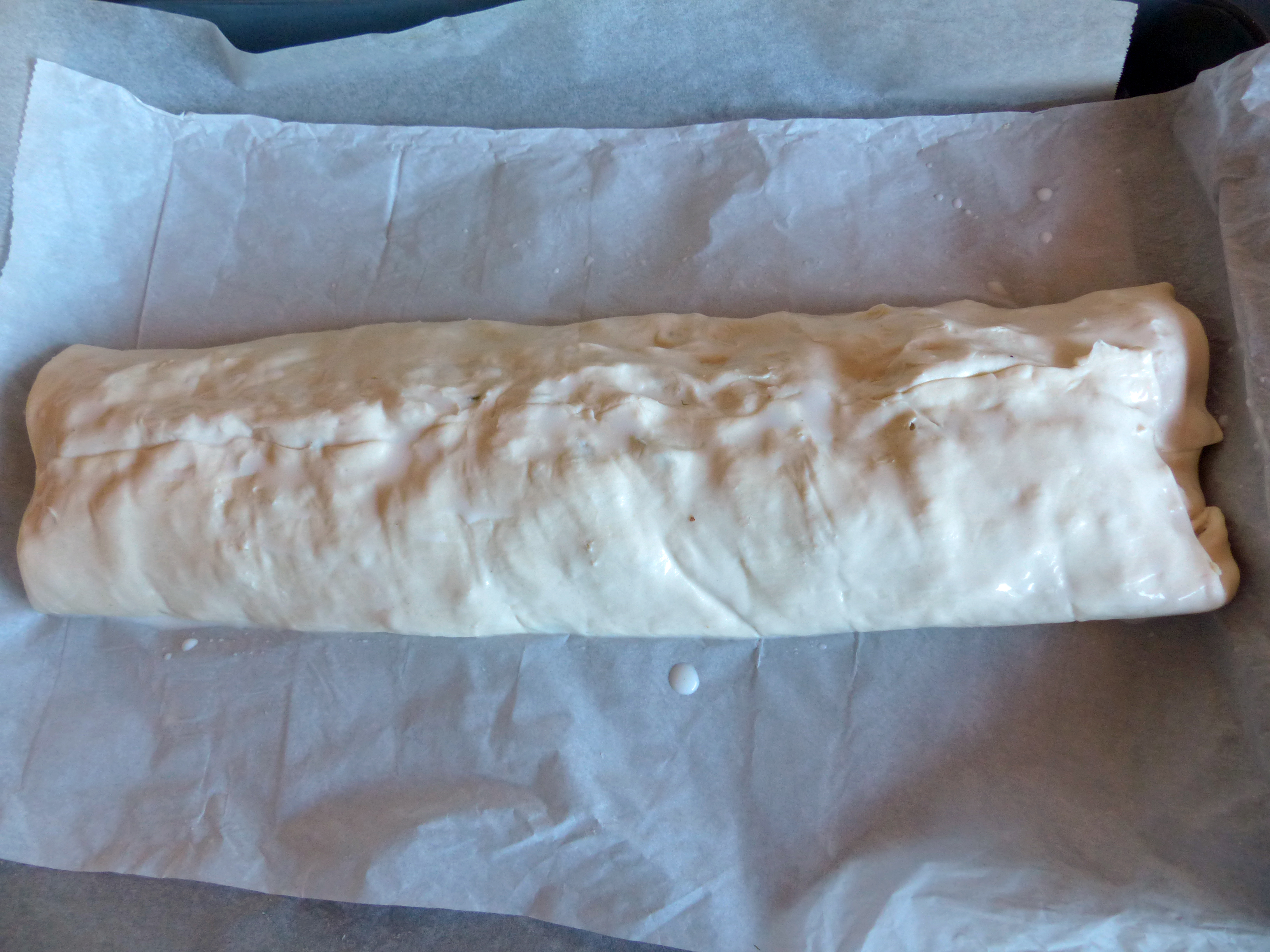 <p>Die zweite Teighälfte überlappend über die Füllung ziehen und andrücken.</p>