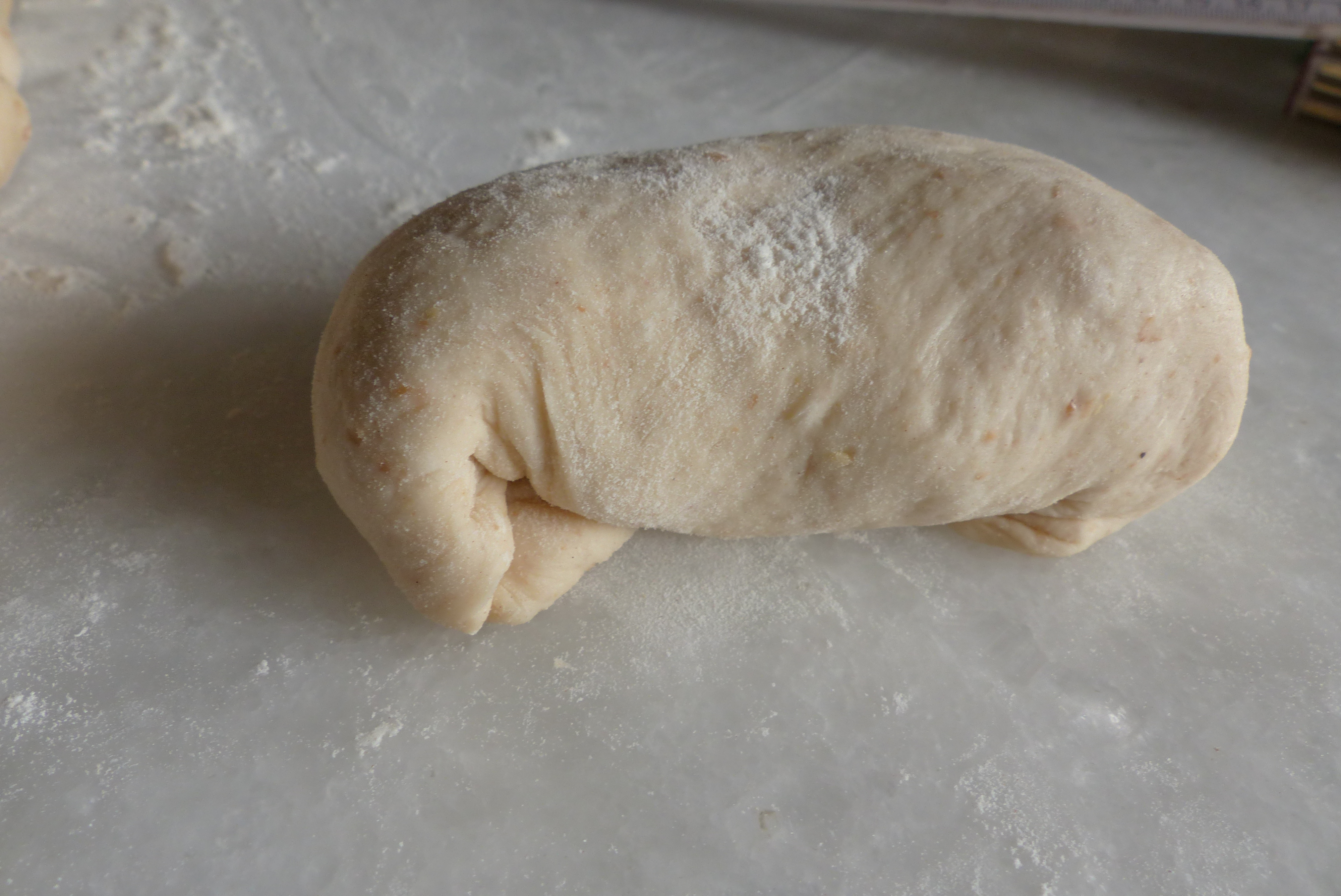 <p>Zu einem länglichen Brötchen von ca. 10 cm formen, mit der Nahtseite nach unten.</p>