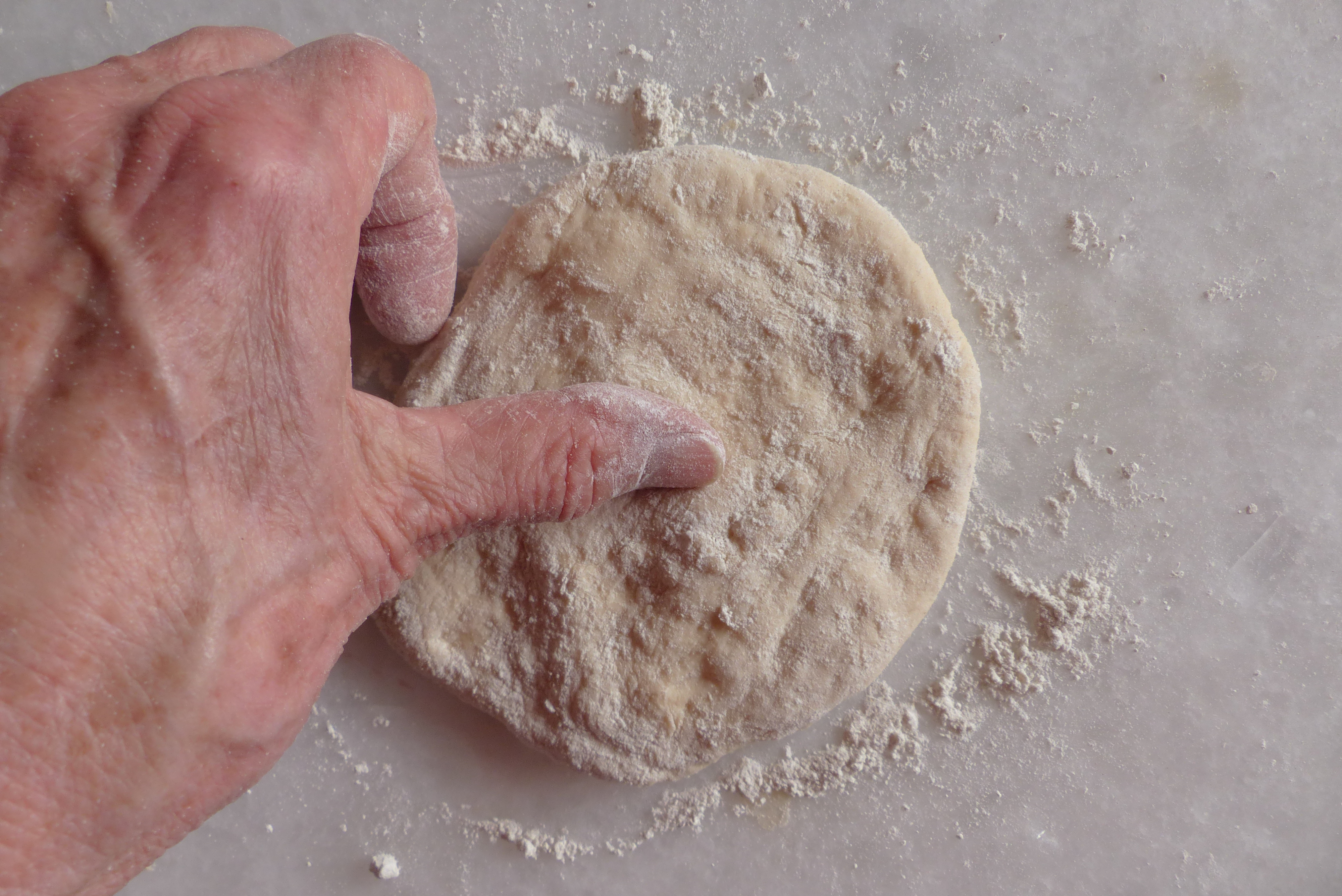 <p>Daumen der linken Hand bleibt auf der Mitte des kleinen Fladens.</p>