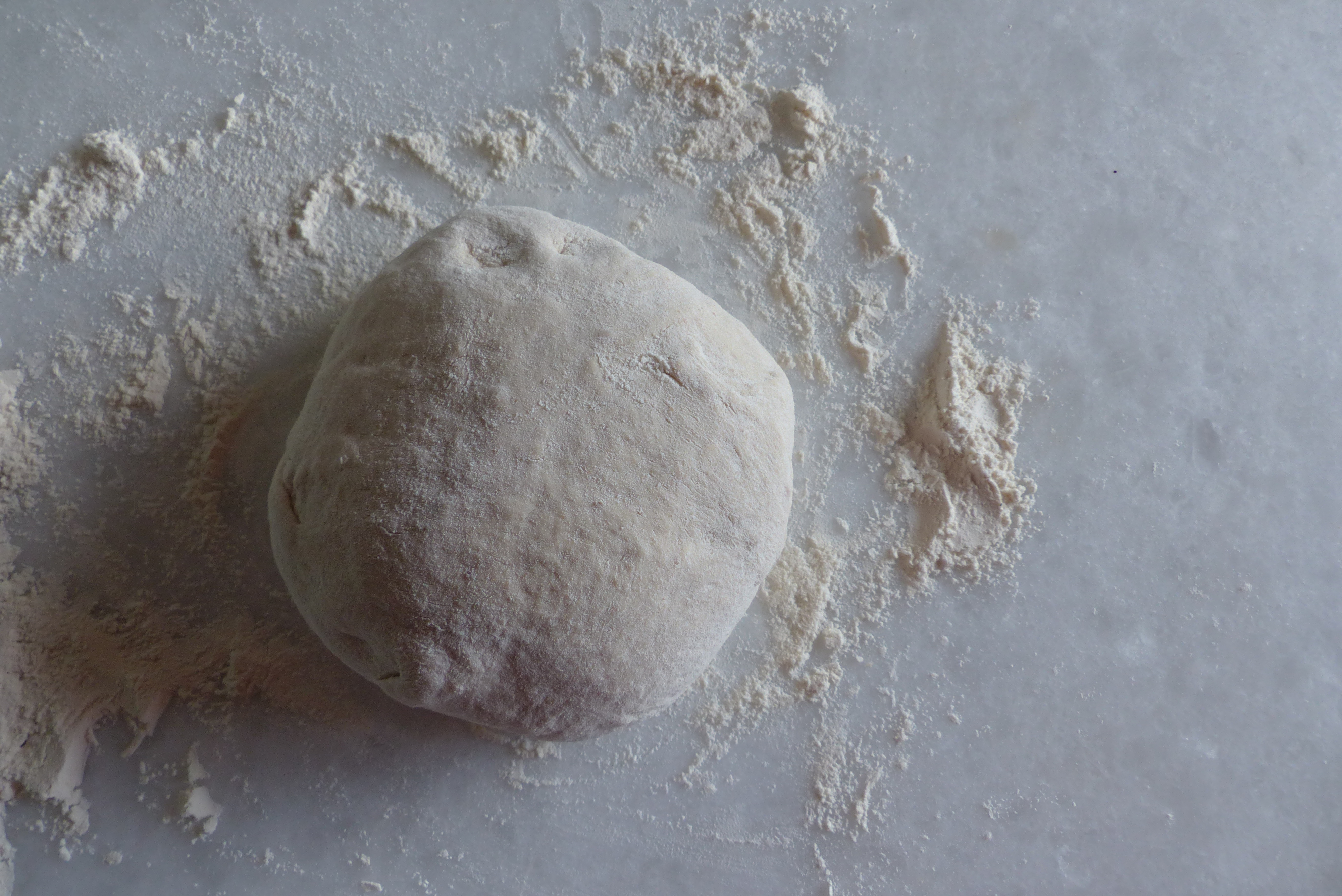 <p>Das <em>Teigpaket wurde gewendet</em>, die Rundung durch kurzes Kreisen zu einer runden Kuppel perfektioniert.</p>