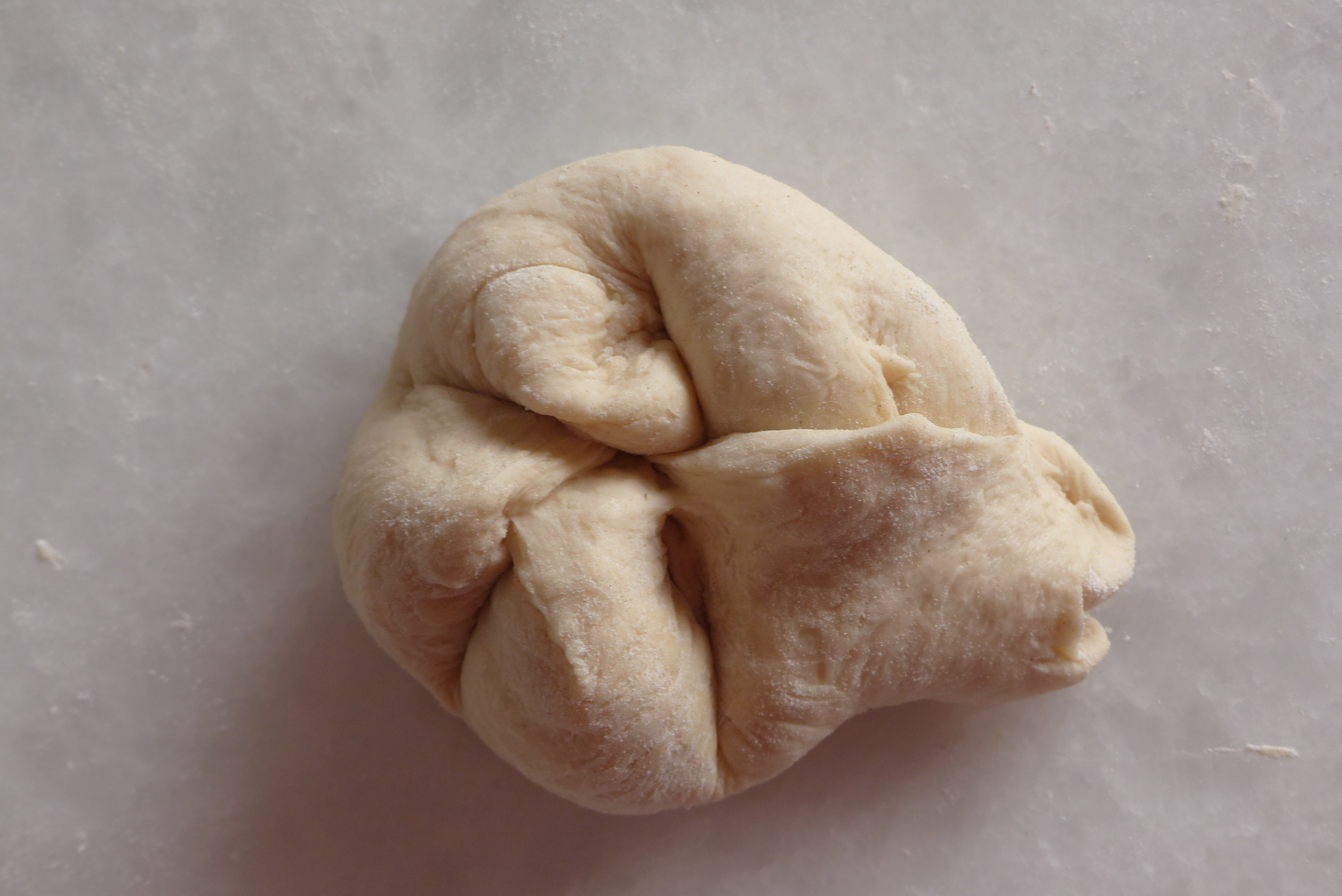 <p>Das Ende (die fünfte Semmelzehe) wird unter die erste Semmelzehe geschoben und am Semmelrand zusammengedrückt, eine Teigzunge entsteht.</p>