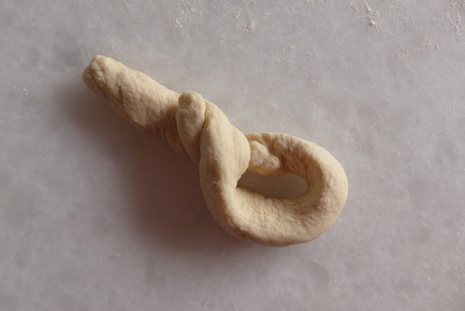 <p>Einstrangzopf - 3. Schritt:<strong> </strong></p><p>Schlaufe von oben nach  u n t e n  gedreht und hingelegt.</p>