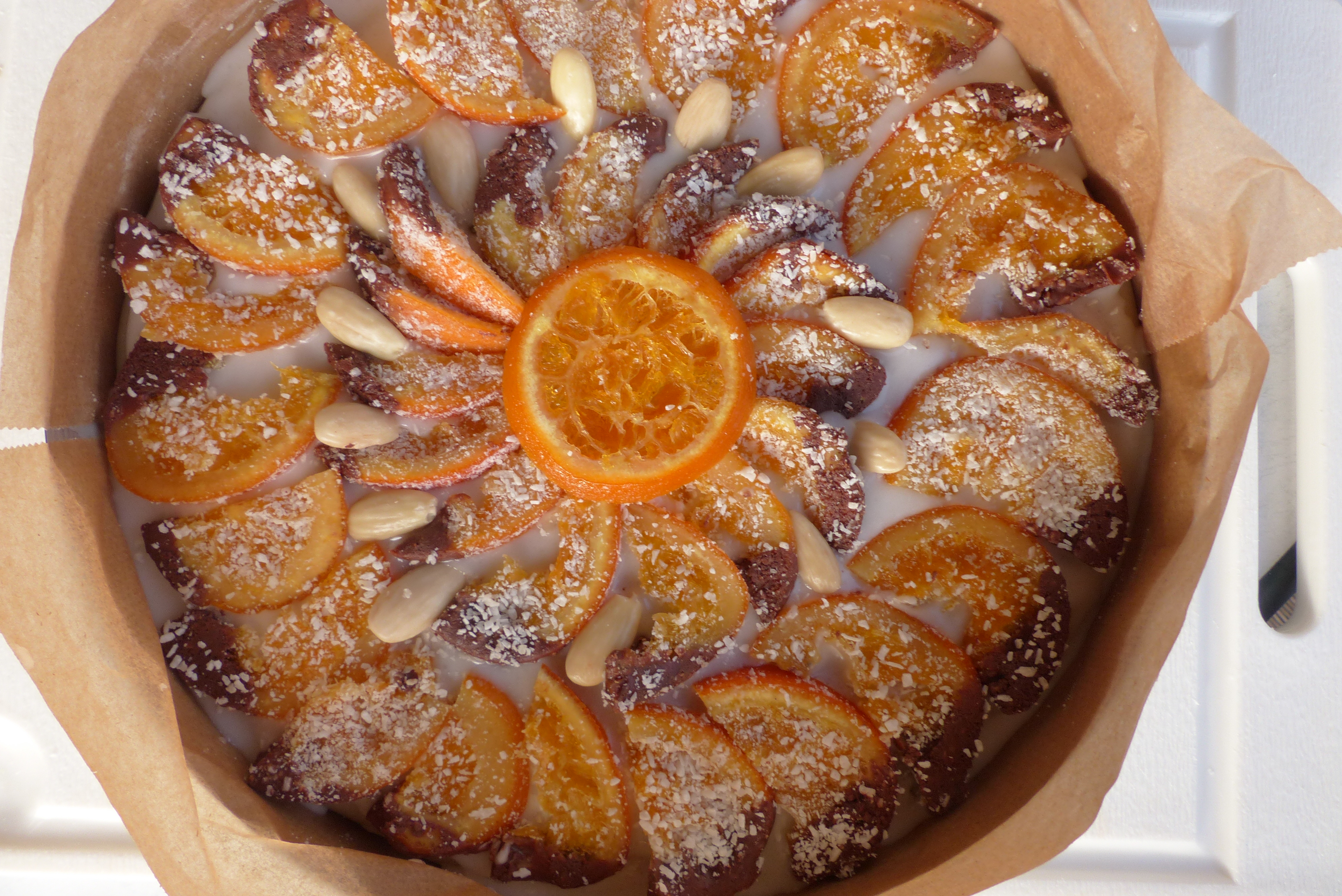 <p>Die Cassata siciliana ruht, eingehüllt in Marzipan und dekoriert mit Zuckerguss und kandieren Orangenscheiben, in einem Tortenring.</p>