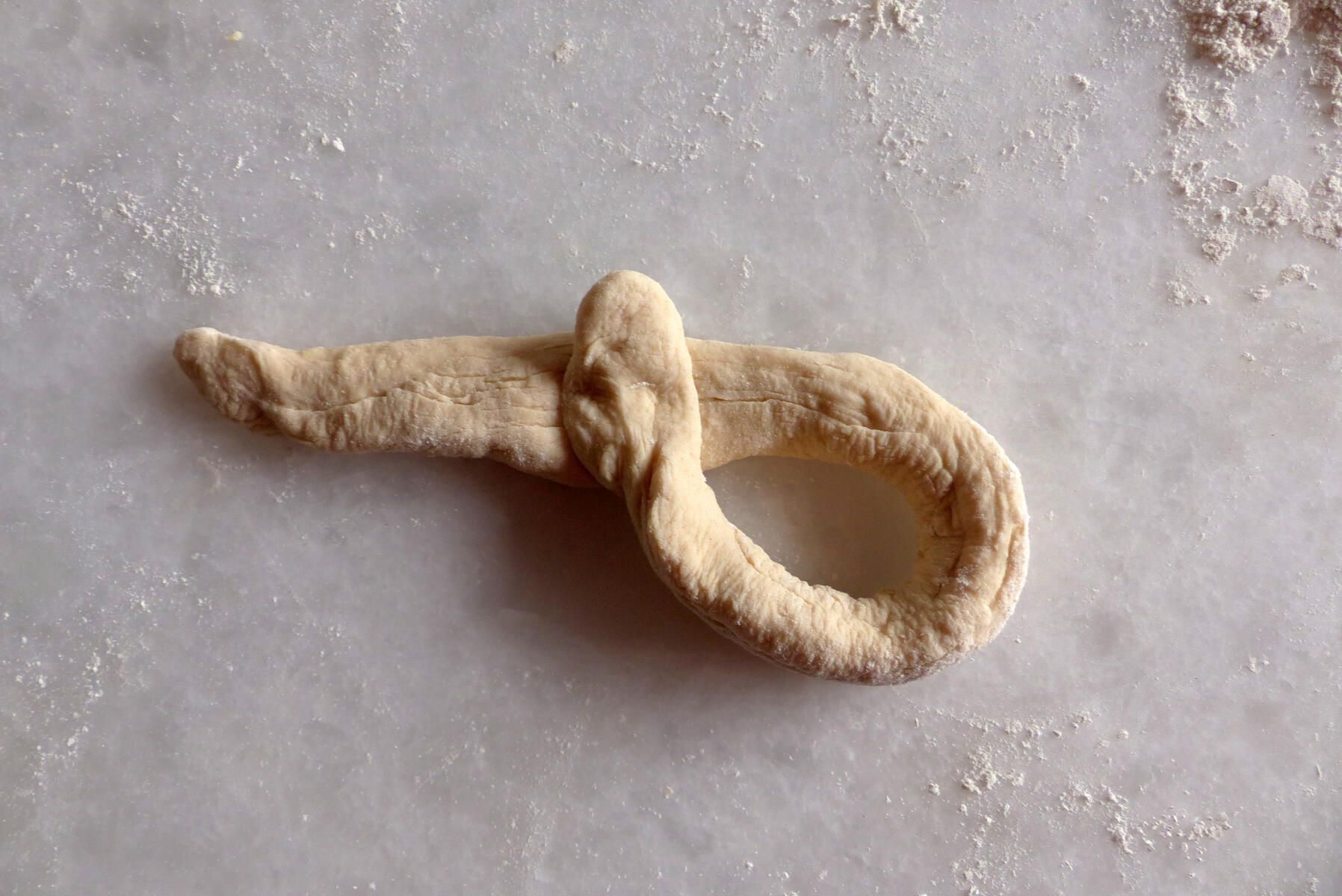 <p>Einstrangzopf - 2. Schritt:<strong> </strong></p><p>Die rundliche Schlaufe wurde gelegt, 1/3 des Stranges bleibt frei.</p>