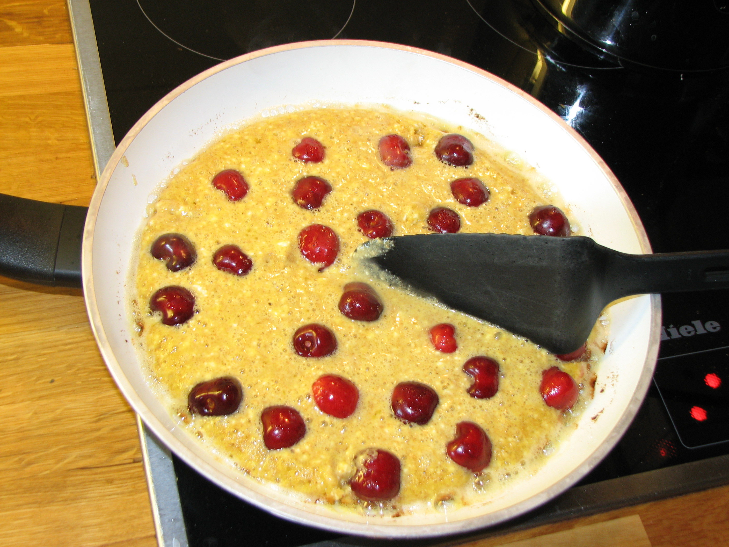 <p>Mit einem Pfannenwender den teigigen Pfannkuchen in vier Teile teilen.</p>